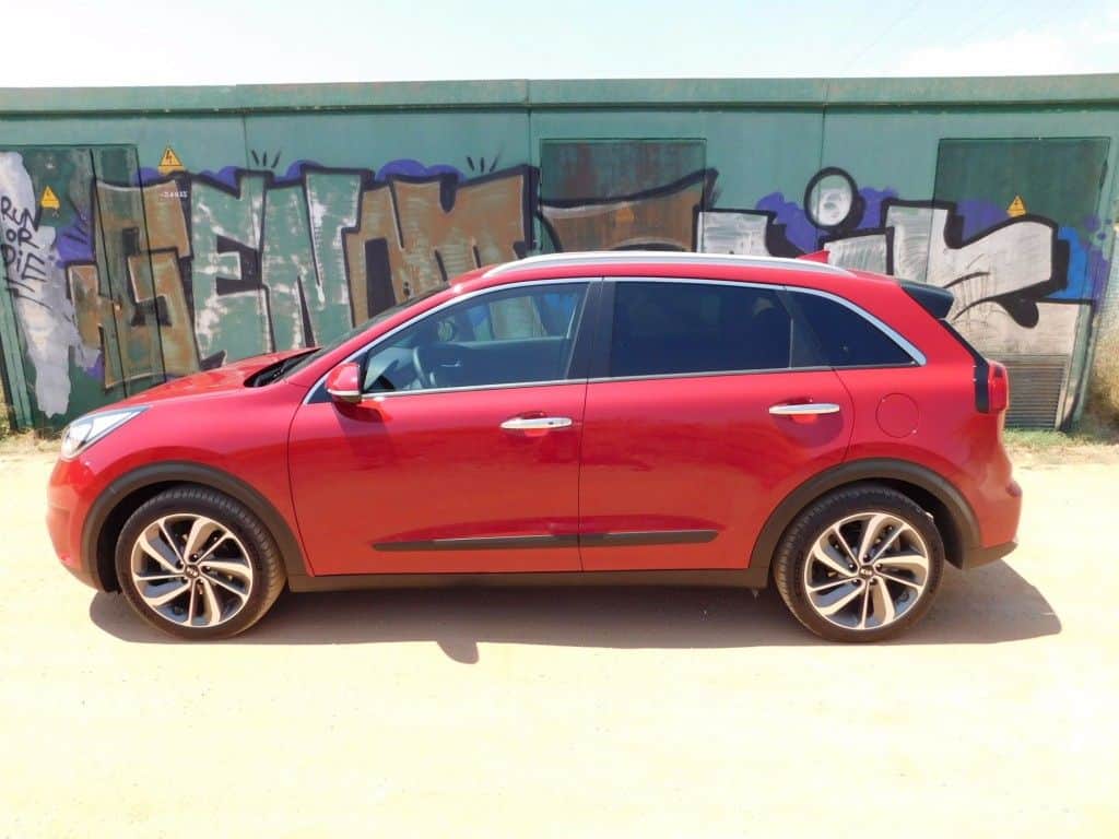 Kia Niro – sparsamer Familien-Crossover fährt vor 3 Kia Niro seitlich